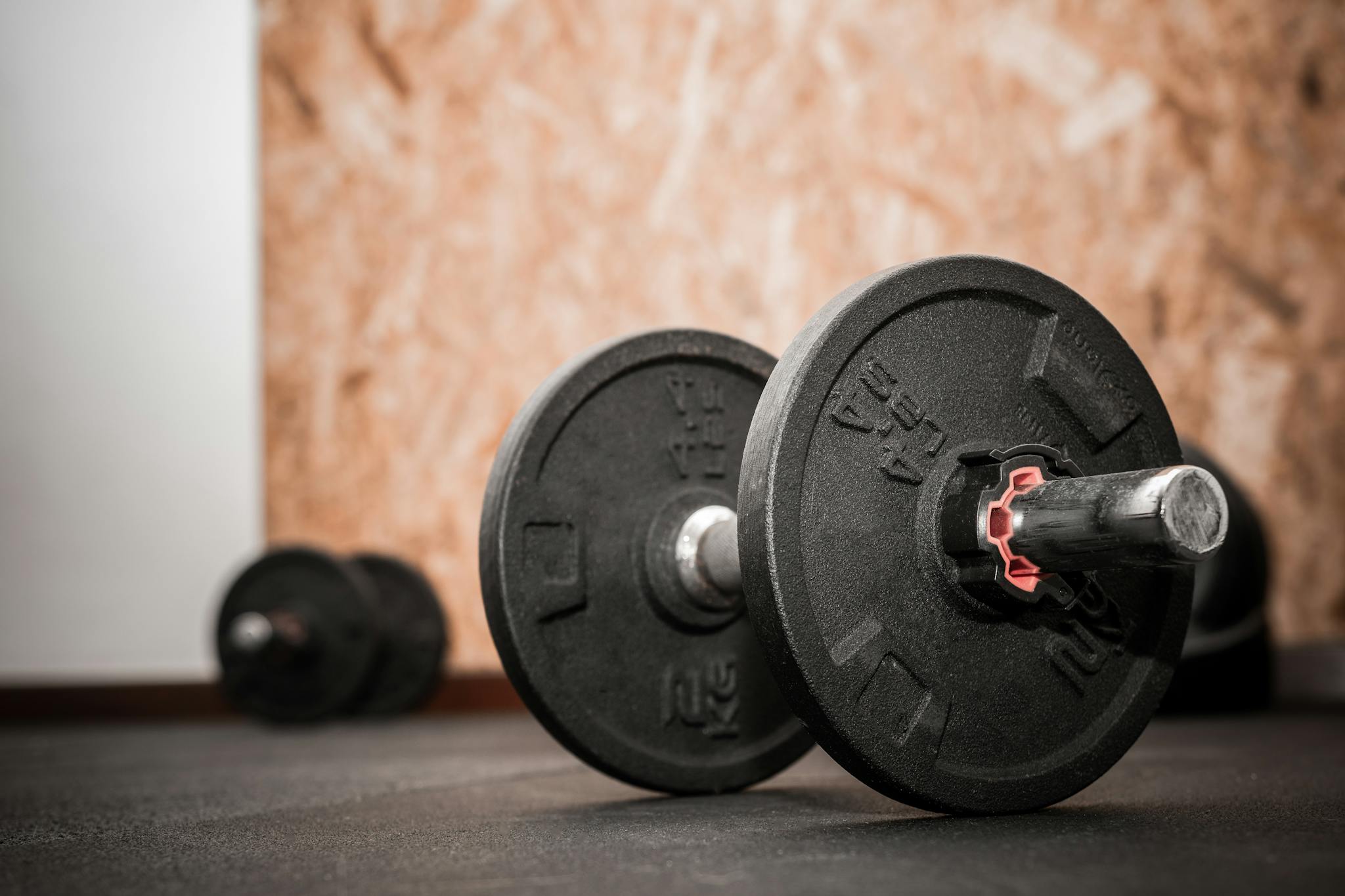 Rustic gym scene showing close-up of dumbbells for weight training.